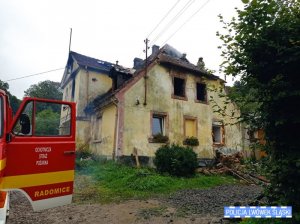 Na zdjęciu widać budynek, w którym wybuchł pożar. Na dachu znajduje się dwóch strażaków