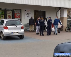 Dwie policjantki przed marketem rozmawiają z mężczyzną