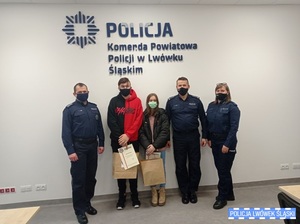 Zdjęcie przedstawia komendanta, policjantkę, policjanta oraz chłopaka i dziewczynę w sali konferencyjnej