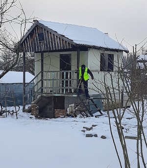 Policjant dokonuje kontroli altanki działkowej w trakcie zimy