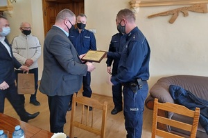 Zdjęcie przedstawia policjanta i samorządowców podczas wręczania podziękowań