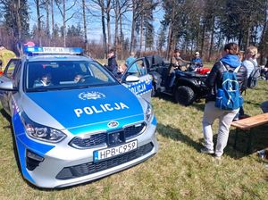 Zdjęcie przedstawia pojazdy policyjne i dzieci