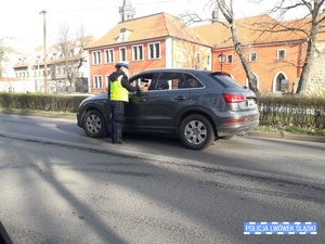 Zdjęcie przedstawia policjantkę przy samochodzie osobowym