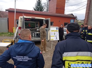 Zdjęcie przedstawia dowódcę zbiórki oraz dookoła strażaków przy tablicy