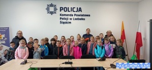 Zdjęcie grupowe dzieci, nauczycielek i policjantki w komendzie