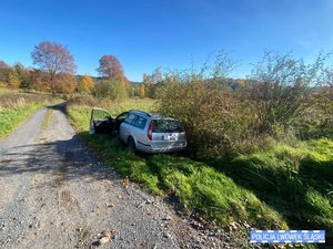 Srebrny samochód osobowy poza drogą publiczną