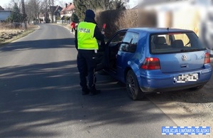 Policjant kontroluje niebieski samochód