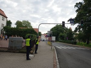 Policjanci stoją przy przejściu dla pieszych w pobliżu szkoły